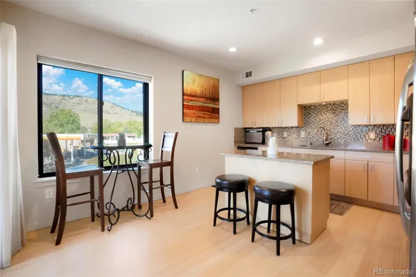 a kitchen with kitchen island a table and chairs in it