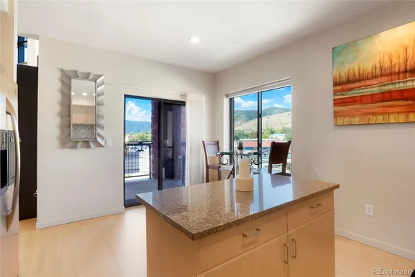 a dining hall with stainless steel appliances granite countertop a sink dishwasher and cabinets with wooden floor