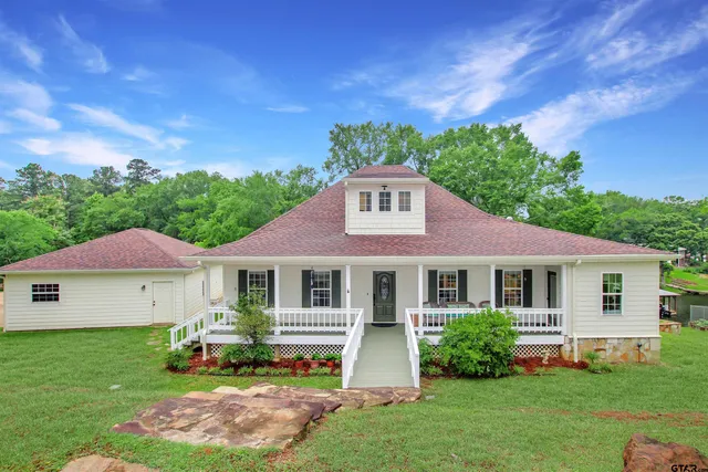 a front view of a house with a garden and plants