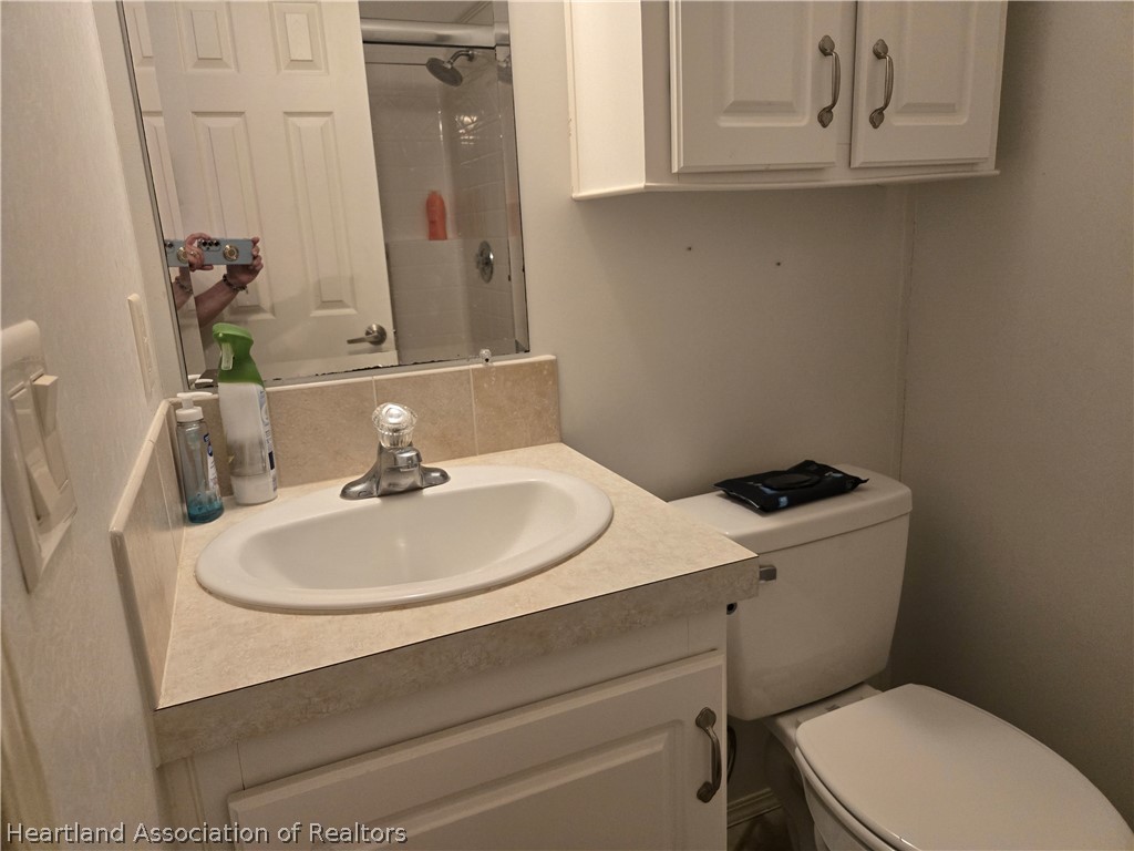 504 Thunderbird Hill Road Sebring, FL 33872 - Photo 22 of 35 a bathroom with a sink a toilet and mirror