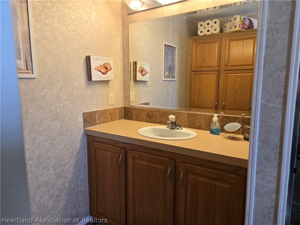 504 Thunderbird Hill Road Sebring, FL 33872 - Photo 27 of 35 a bathroom with a sink and a mirror