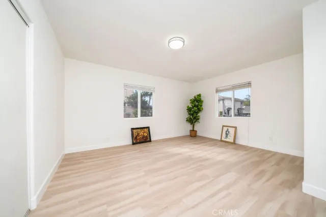a view of a bedroom with wooden floor and windows