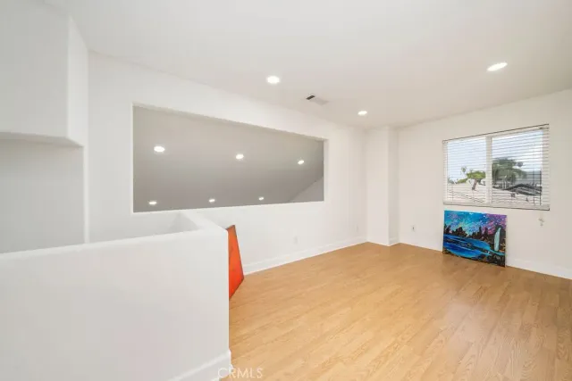 a view of a big room with wooden floor and windows