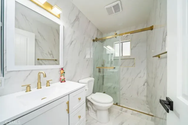 a bathroom with a sink toilet a mirror and shower