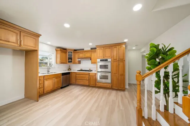 a kitchen with stainless steel appliances a refrigerator a sink a stove a microwave and cabinets