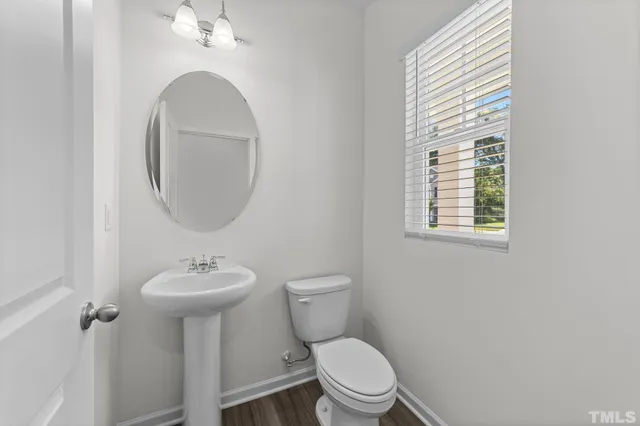 a bathroom with a toilet sink vanity and mirror