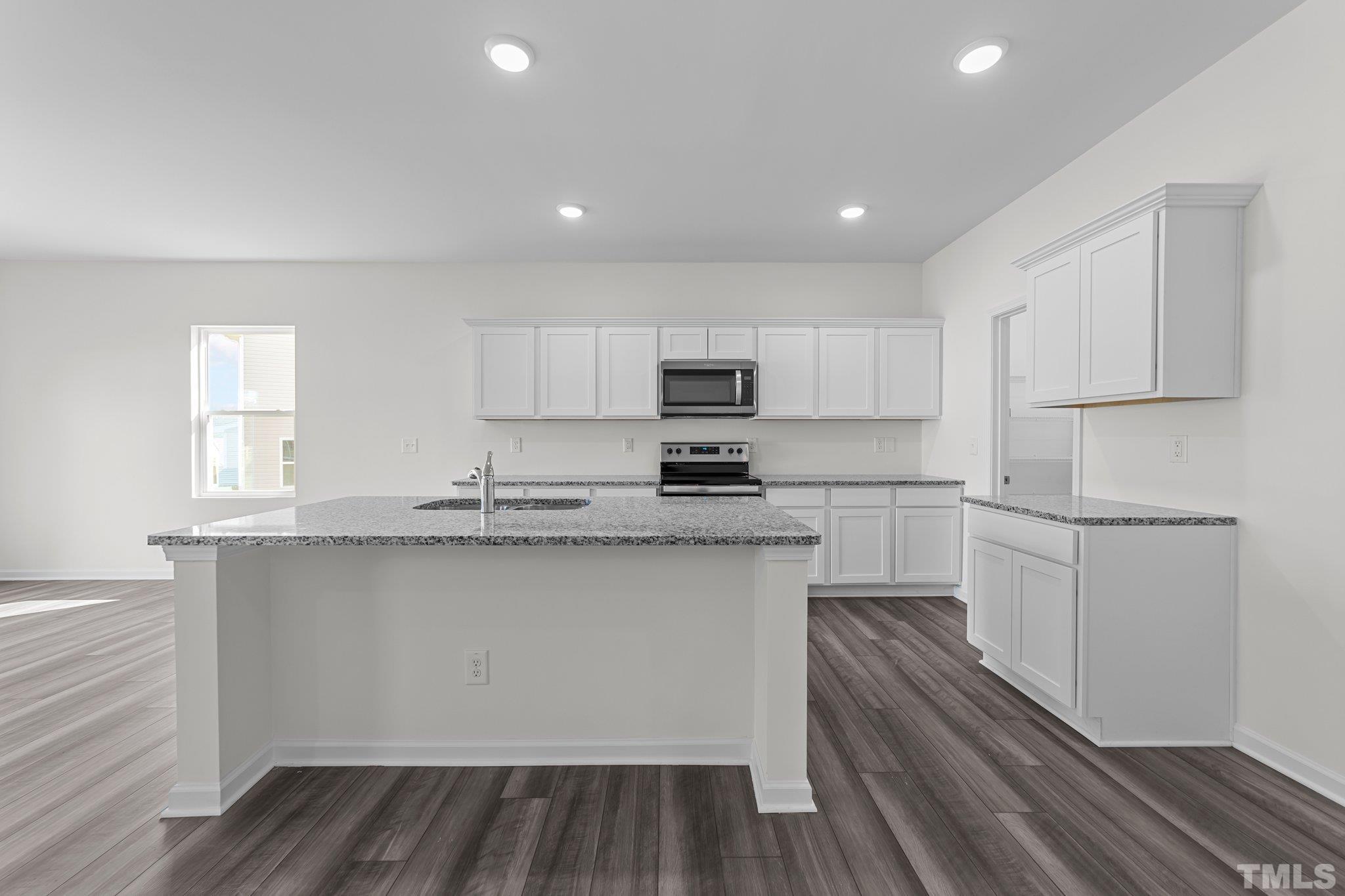 200 Miles Drive Pikeville, NC 27863 - Photo 5 of 34 a kitchen with granite countertop white cabinets and white appliances