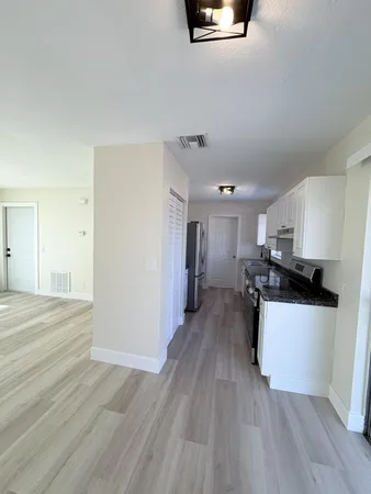 a kitchen with a refrigerator and a stove top oven