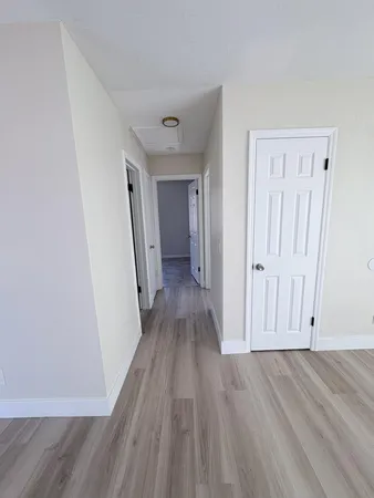 a view of a hallway with wooden floor