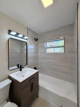 a bathroom with a sink mirror toilet and bathtub