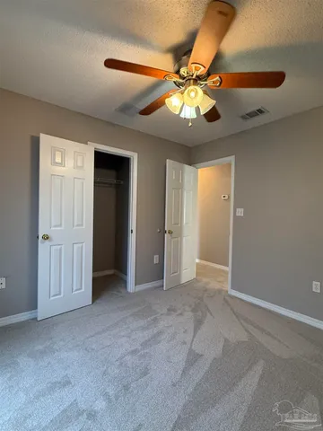 a view of an empty room with a ceiling fan