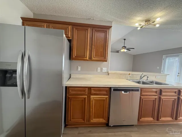 a kitchen with a sink a refrigerator and cabinets