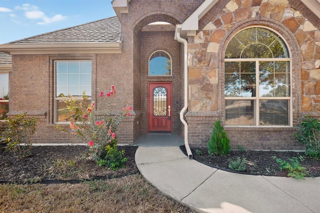 108 Winding Way Azle, TX 76020 - Photo 5 of 38 Brick and stone exterior with arched entryway and large arched window
