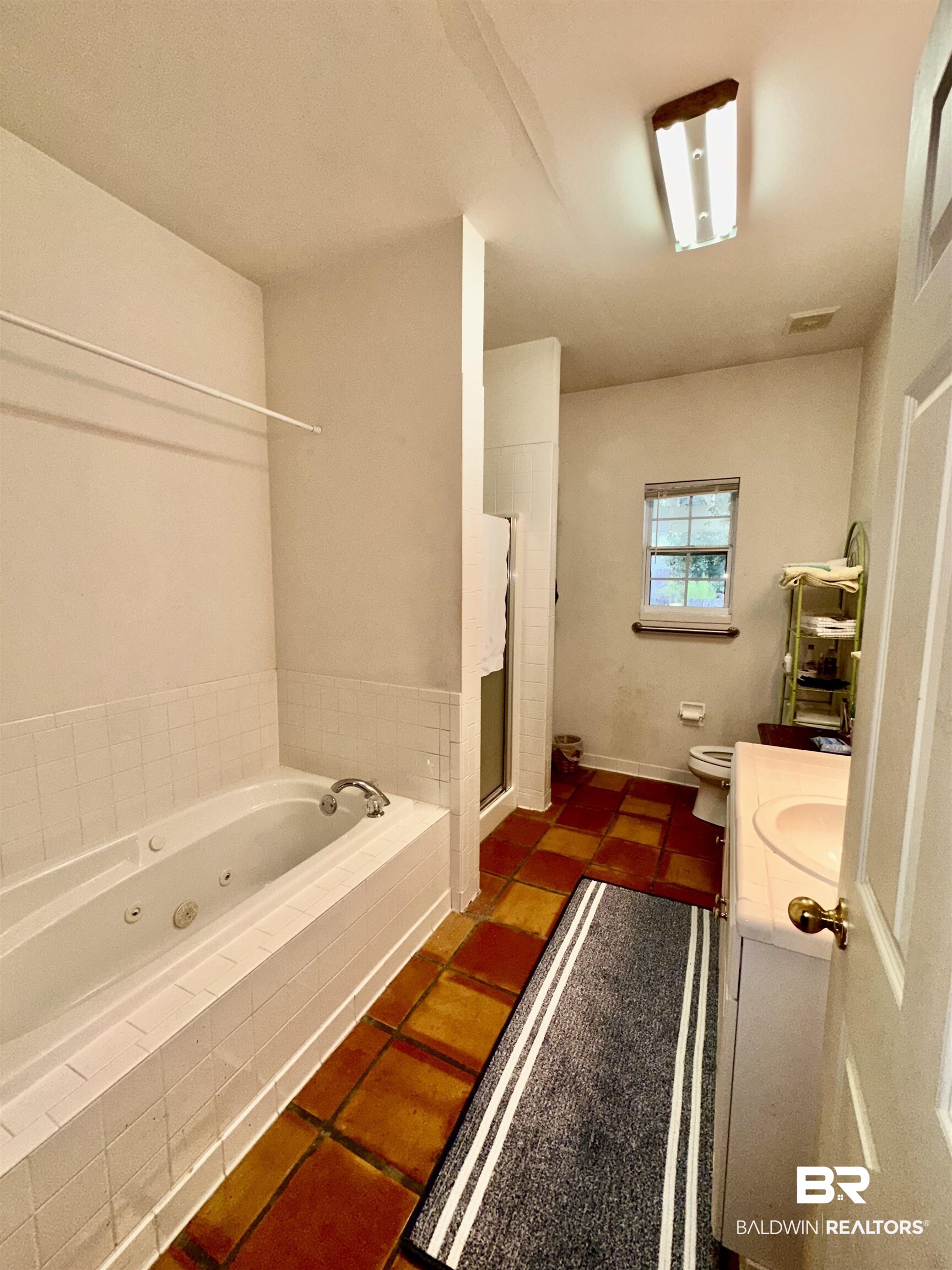 9101 Coronada Road Elberta, AL 36530 - Photo 14 of 27 Full bathroom with vanity, a tub with jets, dark tile patterned flooring, and a stall shower