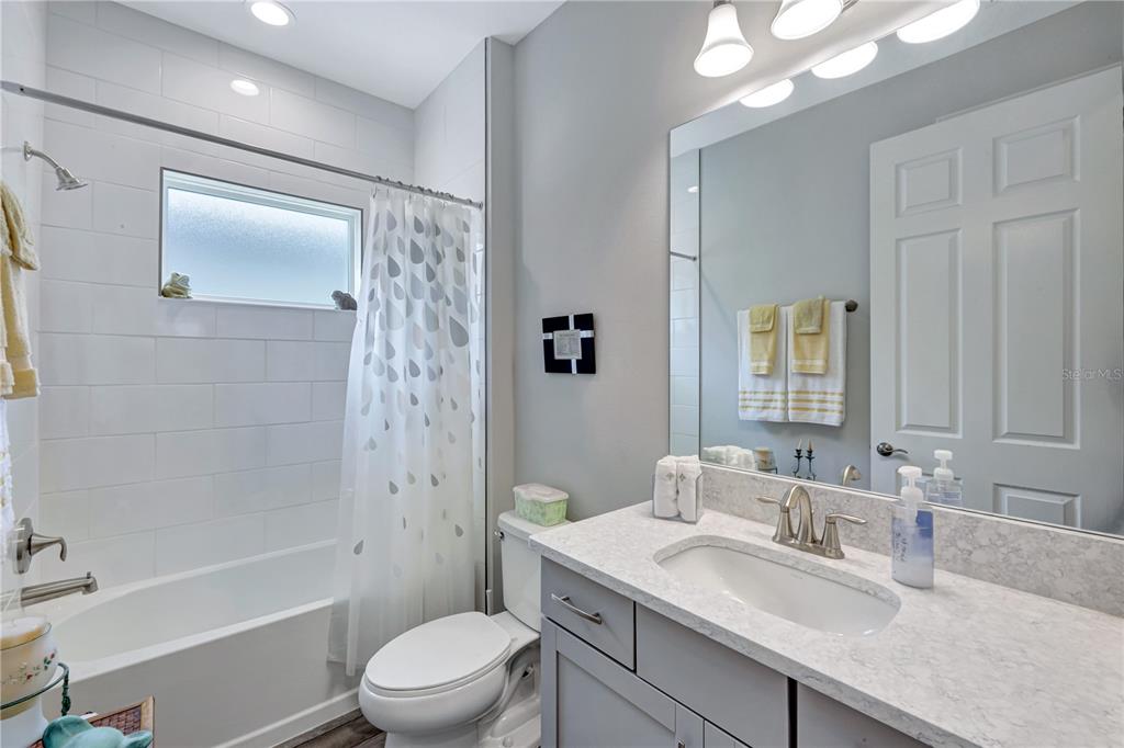 6219 Golden Nettle Drive Apollo Beach, FL 33572 - Photo 18 of 37 a bathroom with a granite countertop sink toilet a large mirror a shower and a bathtub