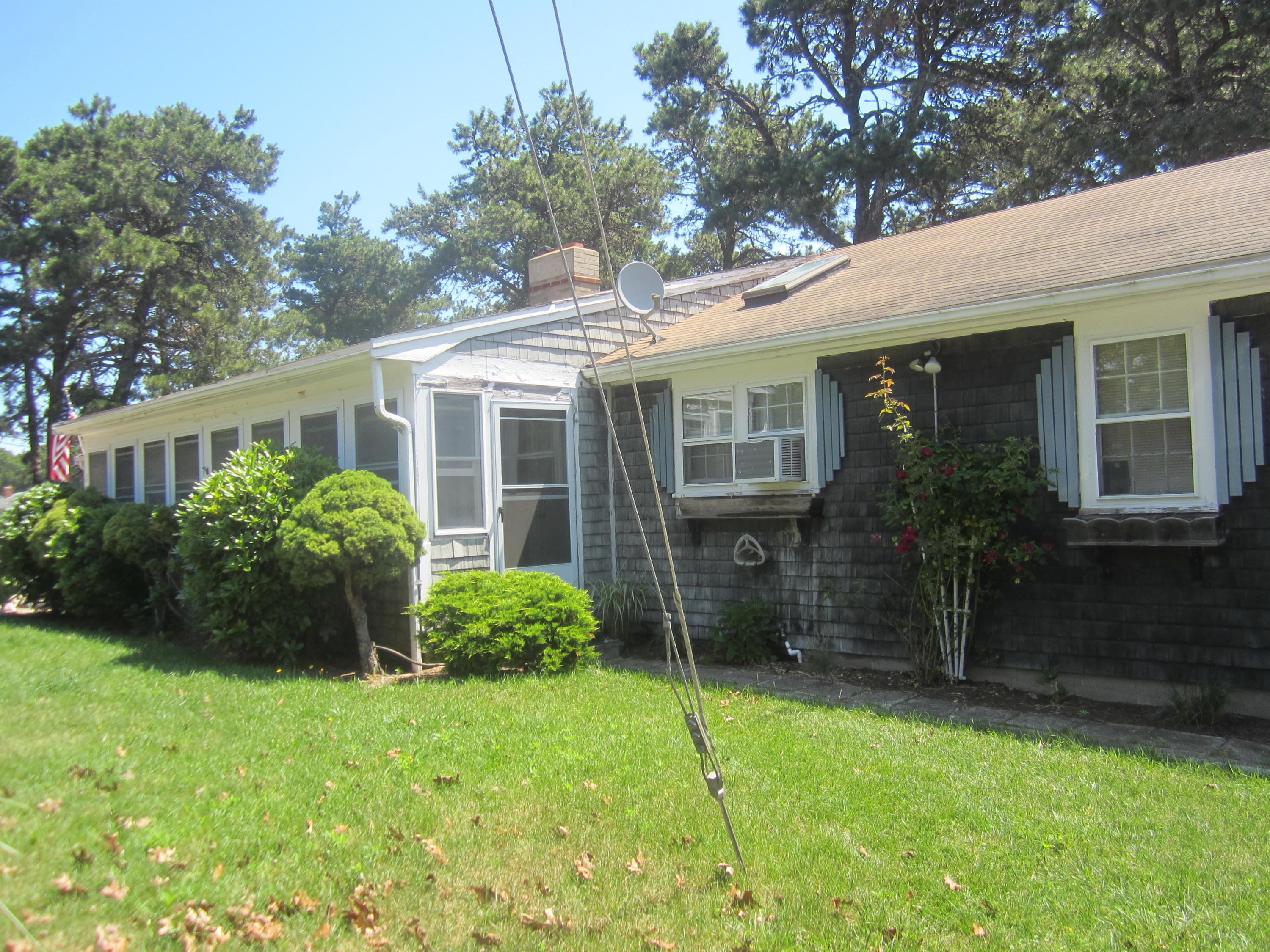 101 Lower County Road, Unit U1A Dennis Port, MA 02639 - Photo 4 of 10 a view of a house with brick walls and a yard with plants