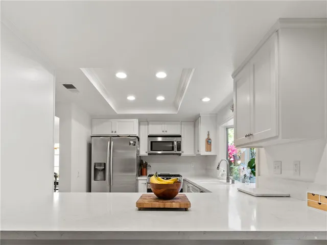 a kitchen with stainless steel appliances granite countertop a refrigerator sink and stove