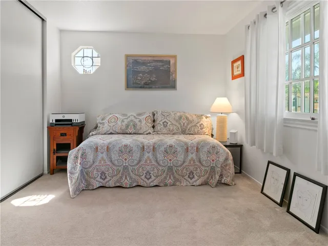 a bedroom with a bed and a lamp on dresser