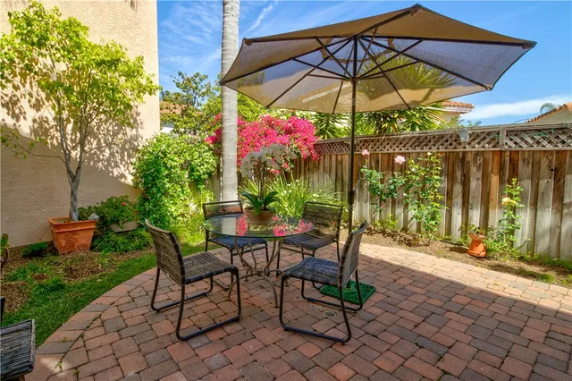 a view of patio with chairs and table under an umbrella
