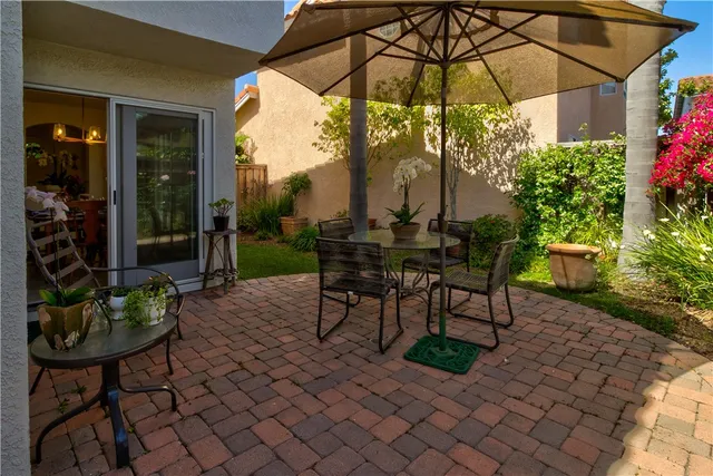 a view of a chair and table in backyard of the house