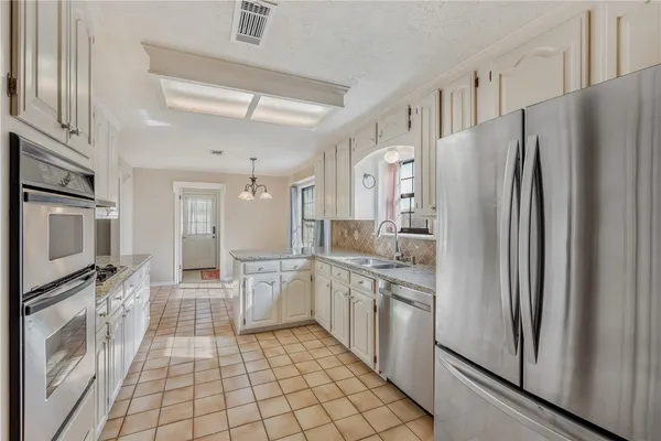 a kitchen with stainless steel appliances a refrigerator sink and microwave
