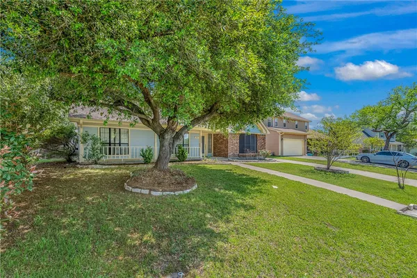 a view of a house with a big yard and large trees