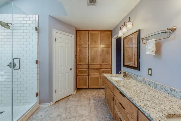 a bathroom with a granite countertop sink and shower