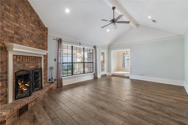 wooden floor fireplace and windows in an empty room