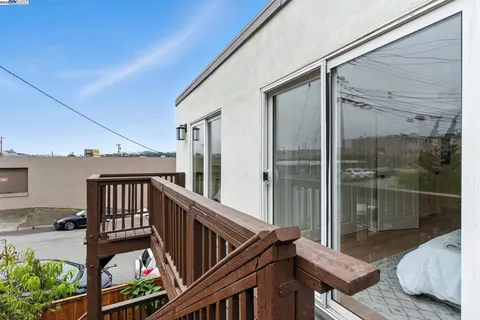 a kitchen with a refrigerator a microwave a stove and white cabinets with wooden floor