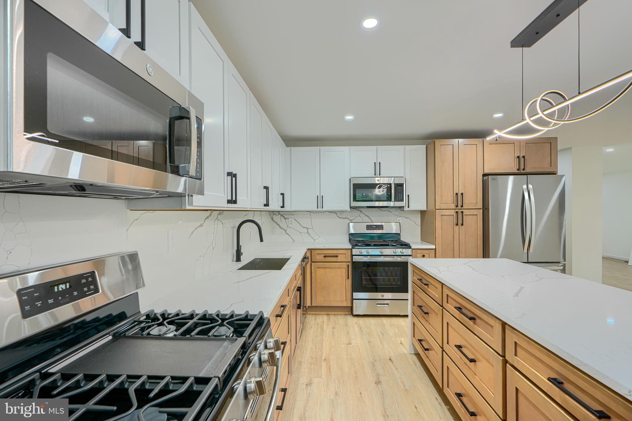 3410 Pinkney Road Baltimore, MD 21215 - Photo 4 of 55 a kitchen with stainless steel appliances granite countertop a stove top oven a sink dishwasher a refrigerator and cabinets with wooden floor