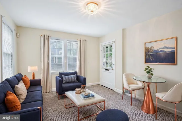 a living room with furniture a rug and a window