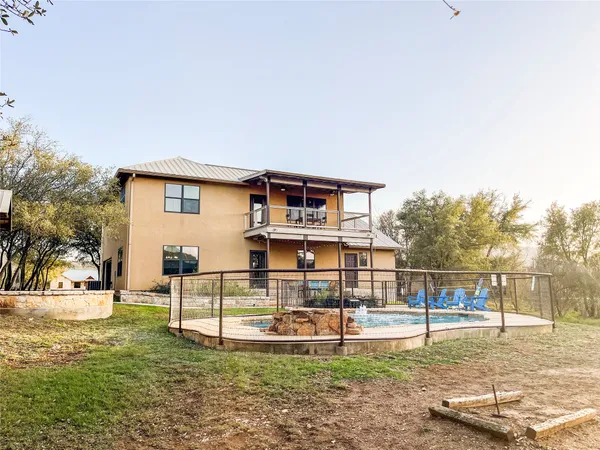 a view of a house with backyard and a tree