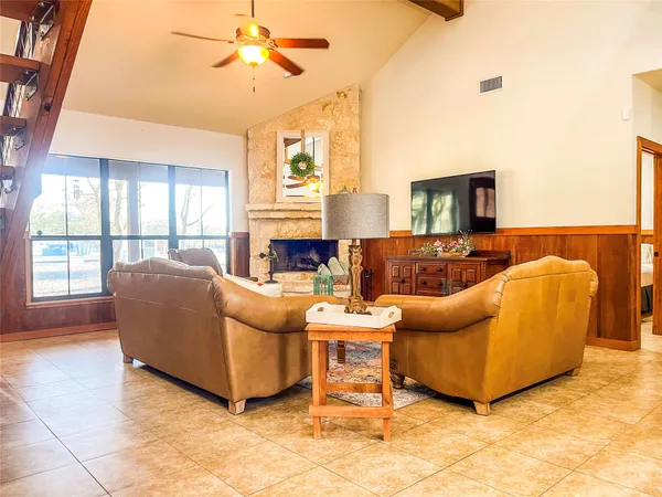 a living room with furniture a large window and a fireplace