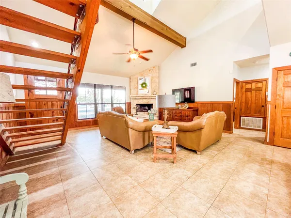 a living room with furniture a flat screen tv and a floor to ceiling window