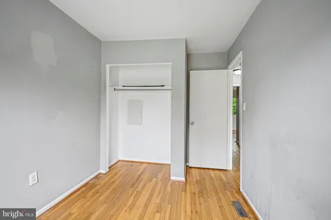 a view of a room with wooden floor and a hallway