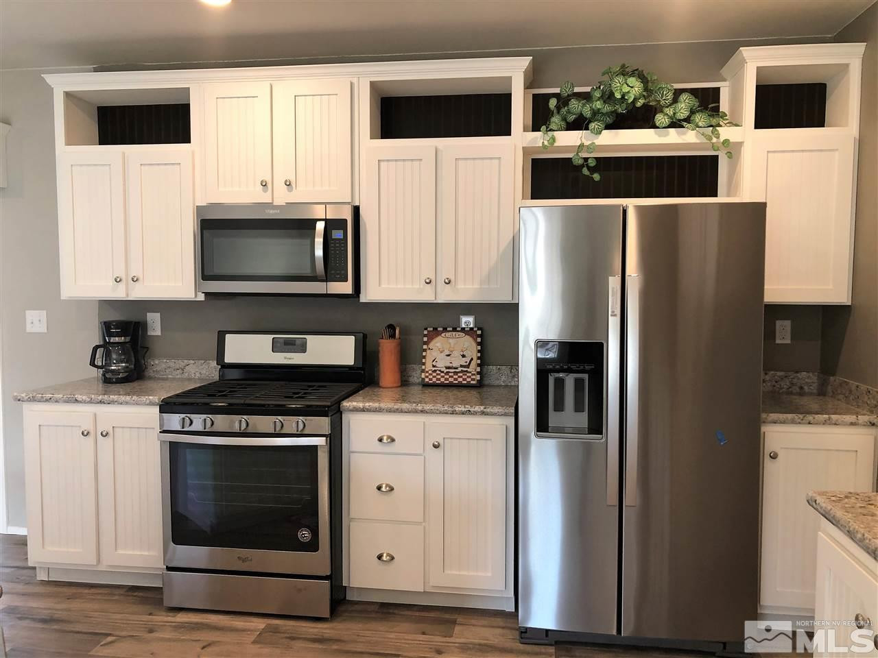 15380 Tuxon Way Reno, NV 89521 - Photo 3 of 25 a kitchen with stainless steel appliances a stove a microwave and a refrigerator