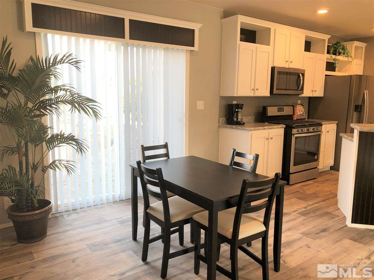 15380 Tuxon Way Reno, NV 89521 - Photo 10 of 25 a kitchen with stainless steel appliances a dining table and chairs