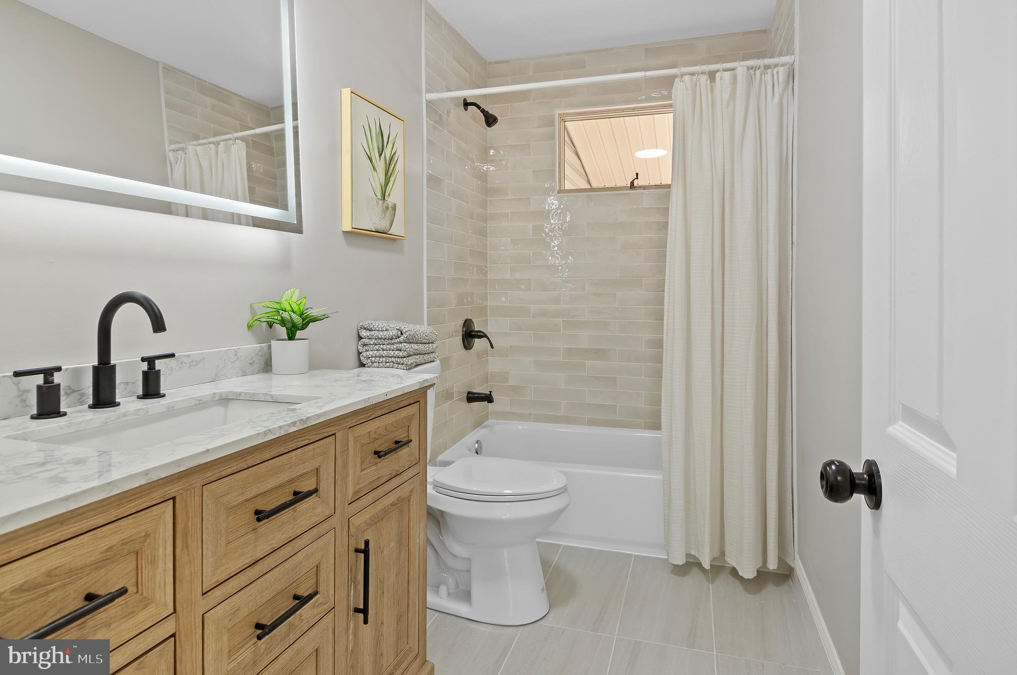 1237 Willow Road Dundalk, MD 21222 - Photo 20 of 29 a bathroom with a granite countertop sink a toilet and shower