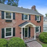 front view of a brick house with a yard