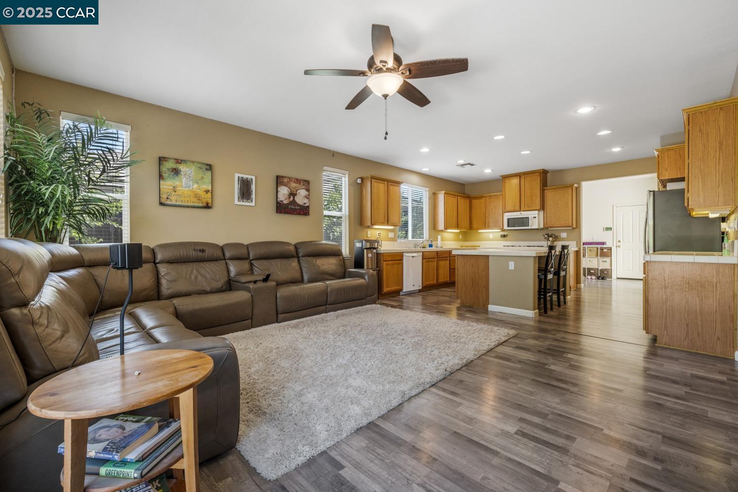 1117 Van Gogh Lane Patterson, CA 95363 - Photo 14 of 55 a living room with furniture kitchen view and a wooden floor
