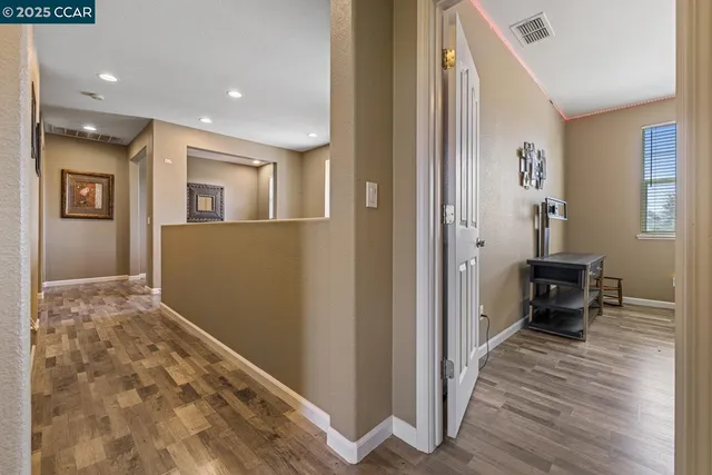 a view of a hallway and closet with wooden floor