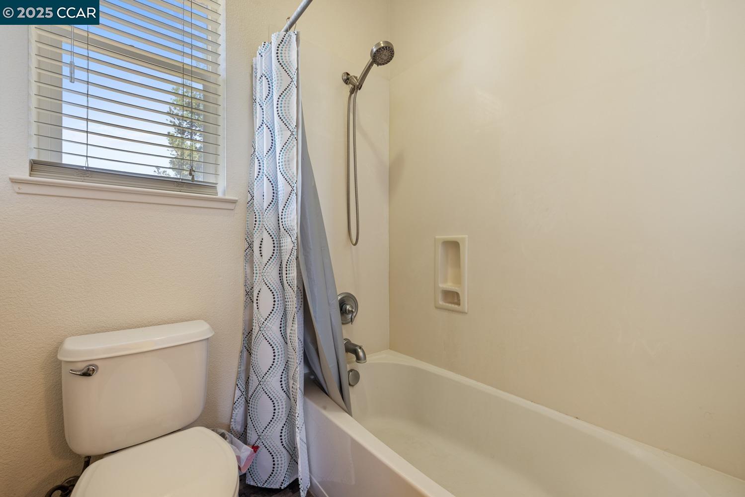 1117 Van Gogh Lane Patterson, CA 95363 - Photo 32 of 55 a white toilet sitting next to a bath tub and a window