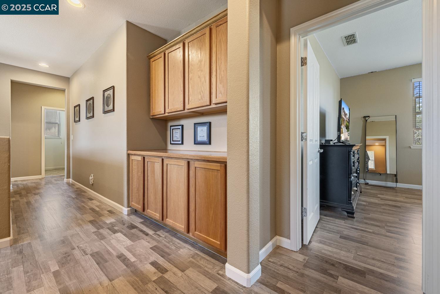 1117 Van Gogh Lane Patterson, CA 95363 - Photo 36 of 55 a view of a hallway with wooden floor and staircase