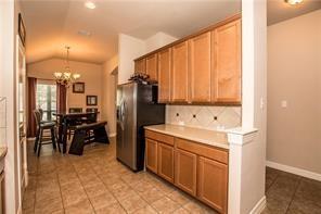 1409 Rosson Road Little Elm, TX 75068 - Photo 26 of 34 Kitchen with light wood cabinetry, light-toned countertops, and a tiled backsplash featuring decorative inserts