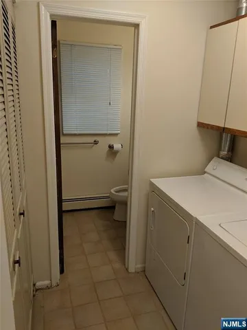a utility room with cabinets washer and dryer