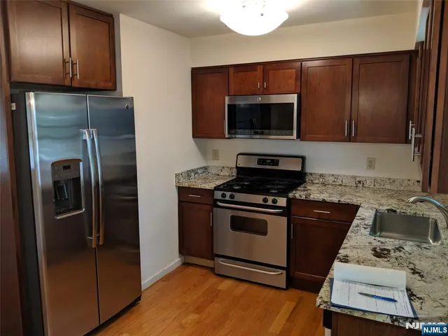 a kitchen with stainless steel appliances granite countertop a refrigerator stove and microwave