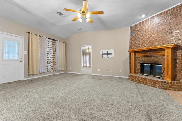 a view of an empty room with a fireplace and a window