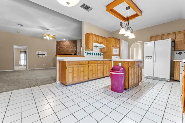 a kitchen with stainless steel appliances granite countertop a sink and a refrigerator