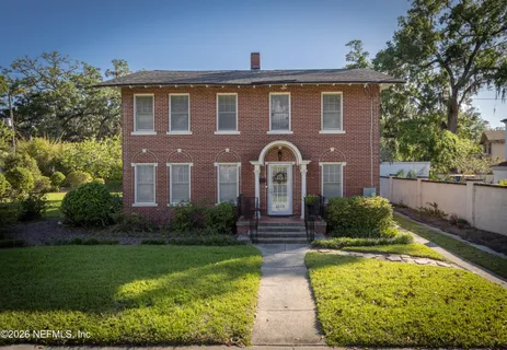 a view of a brick house with potted plants