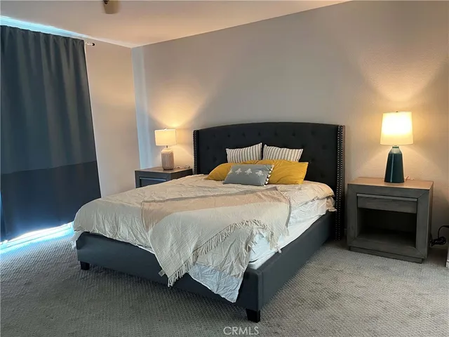 a spacious bedroom with a bed and a window